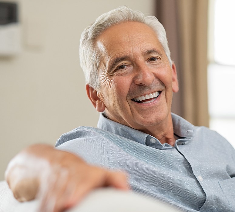 Older man with dentures smiling
