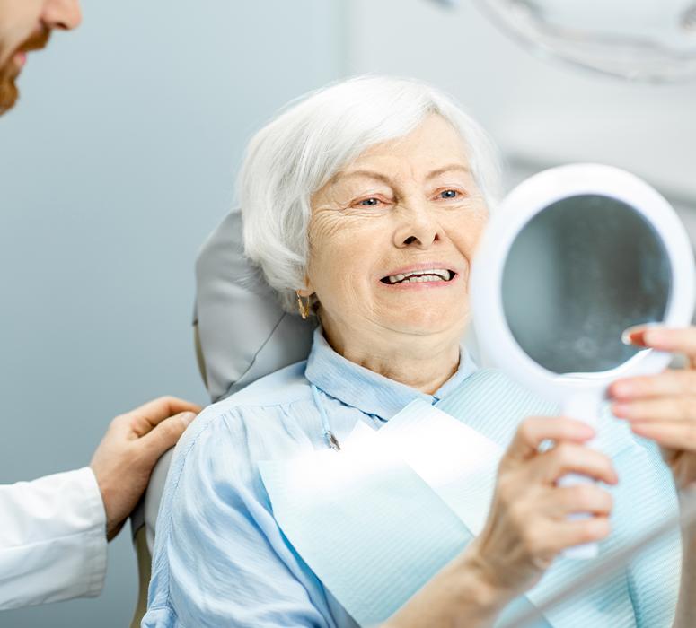 Woman in dental chair after receiving dentures