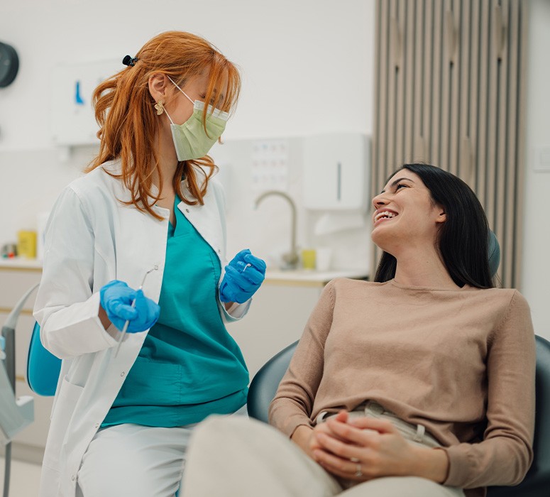 Smiling patient talking to dentist in treatment chair