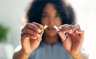 Closeup of woman breaking cigarette