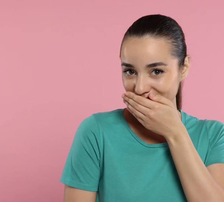 Embarrassed woman covering her mouth