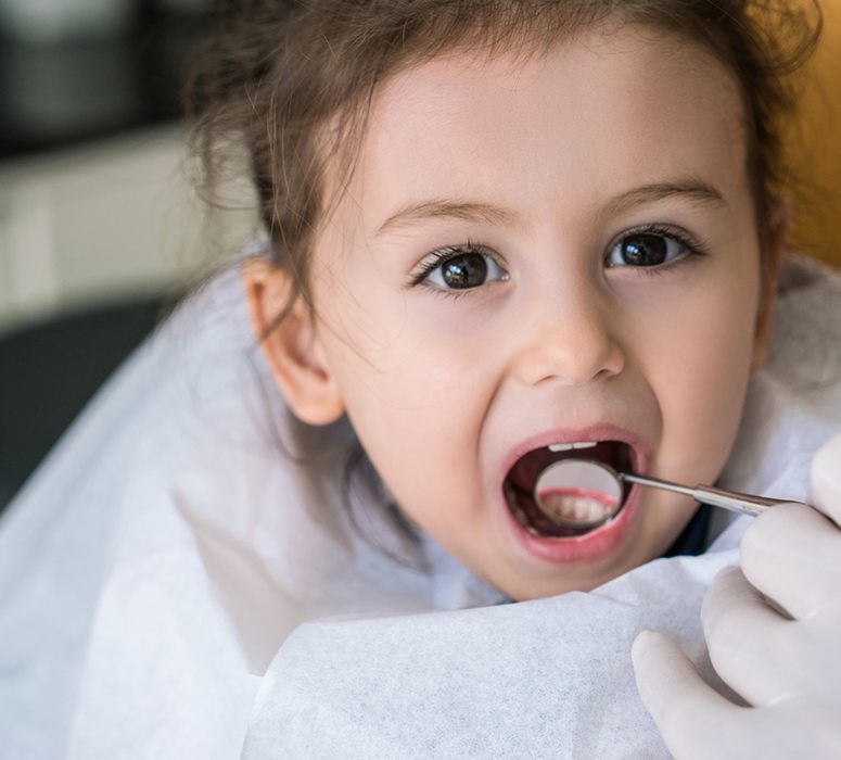 Dentist checking child's tooth colored fillings