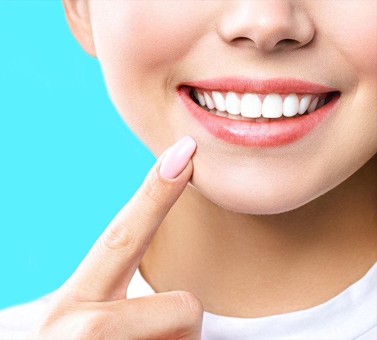 Woman using at home zoom teeth whitening pointing to smile