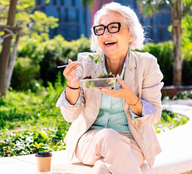 Lady smiles eating salad