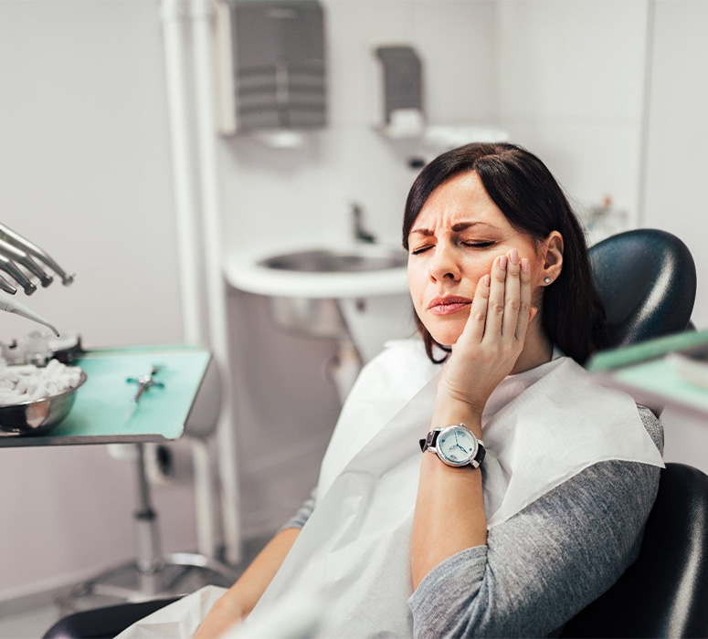 Man in need of emergency dentistry holding jaw in pain