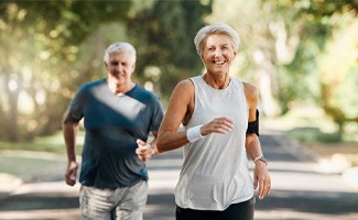 Couple smiling while running on trail outside