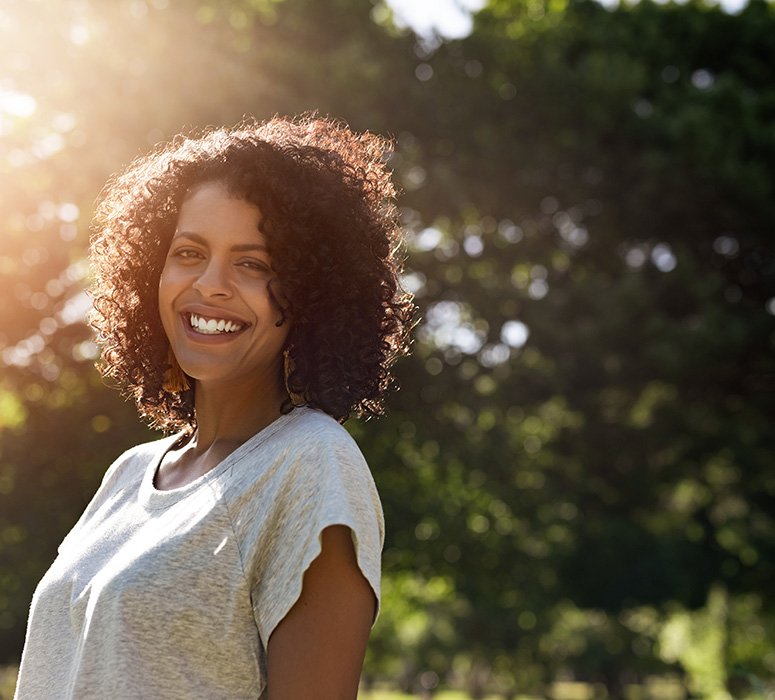 a smiling woman standing outdoors