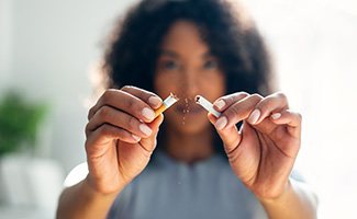 a woman breaking a cigarette in half