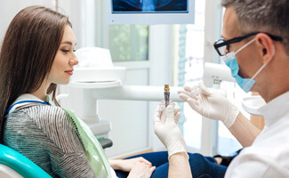 a dentist explaining the parts of a dental implant