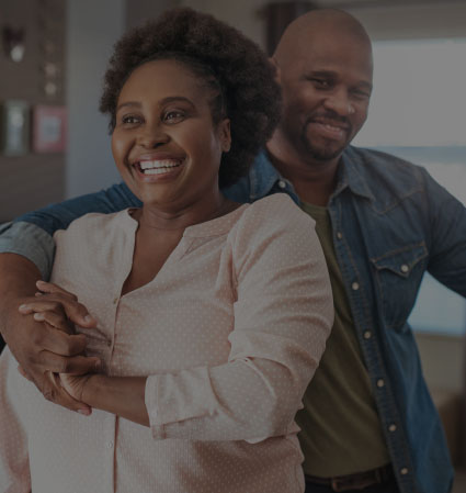 Man and woman smiling in their living room