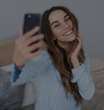 Young woman in light blue blouse taking selfie