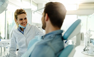 Dentist smiling at patient in treatment chair