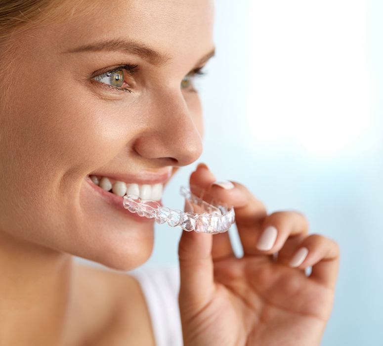 Woman placing keep it straight clear aligner tray