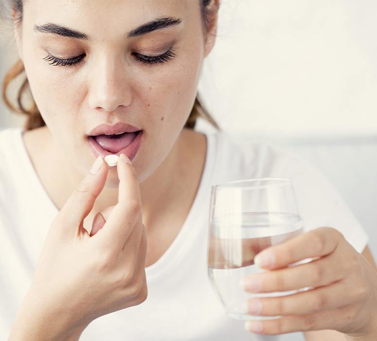 Woman taking oral conscious sedation dentistry pill