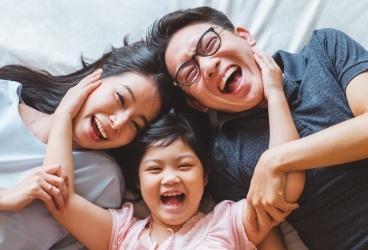 Laughing family with healthy smiles after preventive dentistry