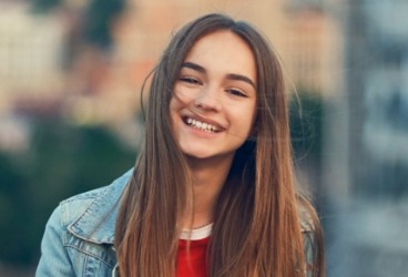 Young woman with healthy smile after clear aligner orthodontic treatment
