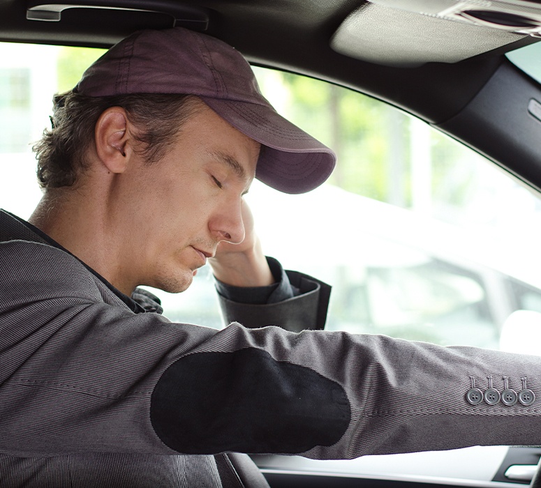 Exhausted man in need of sleep apnea therapy