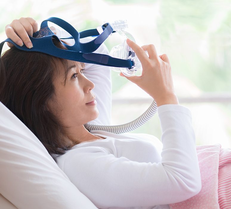 Woman using CPAP appliance for sleep apnea