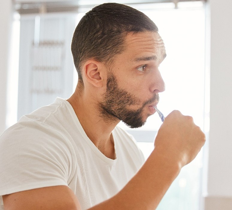 Man brushing his teeth in the bathroom