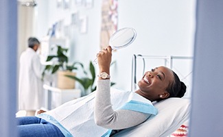 Woman smiling while looking at reflection in mirror