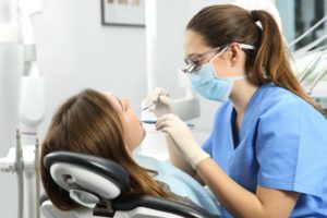 woman getting her teeth cleaned at the dentist 