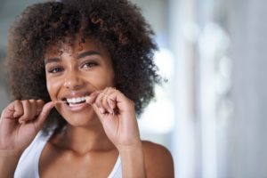 woman smiling while flossing 