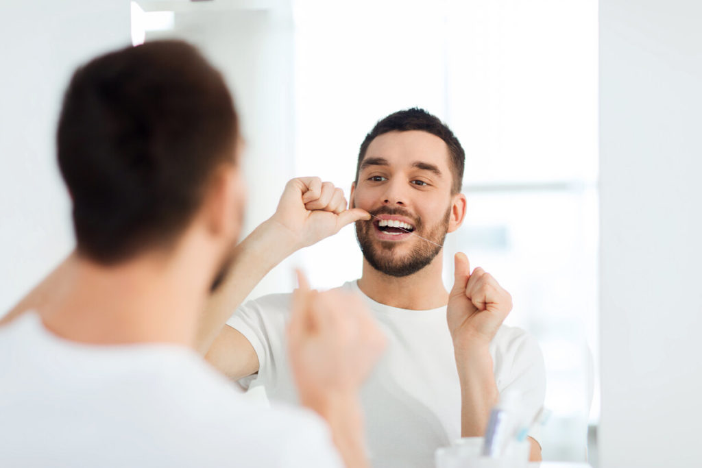 man flossing in Beachwood to prevent health issues