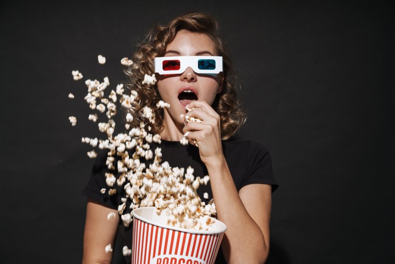 woman eating popcorn and watching a movie