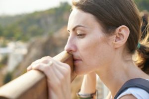 Depressed woman leaning on rail